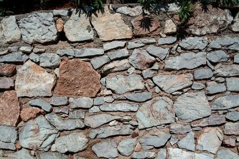 Old stone wall texture background. Rough stone wall. Big rough stones fence Stock Photos
