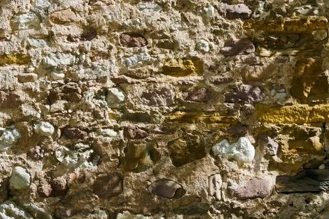 Old stone wall texture with mixed rocks and mortar creating rough rustic ba.. Stock Photos