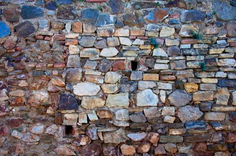 Old stone wall with two small windows Stock Photos
