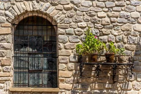Old stone wall with window and plants Stock Photos