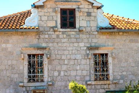 Old stone wall with a window with a grill Foto stock