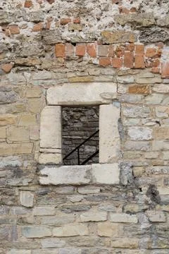 Old stone wall with a window showing a glimpse of stairs inside Stock Photos