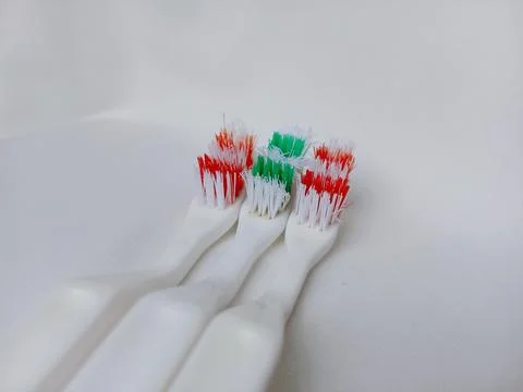 Old striped toothbrushes on white background. Stock Photos