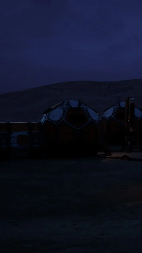 Old structures stand in a desert area during night with a dark sky Video stock 339044334