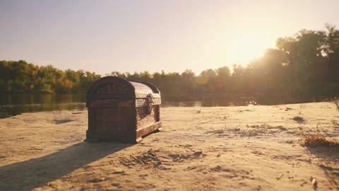 Old style brown chest stands on sand river bank lake sea. Treasure chest wooden Stock Footage 311230924