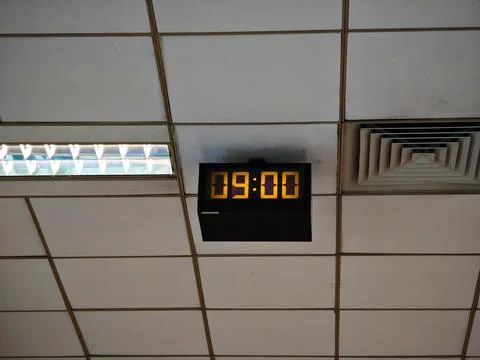 Old style electronic watch on the ceiling. Vintage digital clock. Industrial Foto stock
