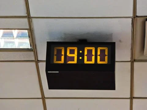 Old style electronic watch on the ceiling. Vintage digital clock. Industrial Stock-Fotos