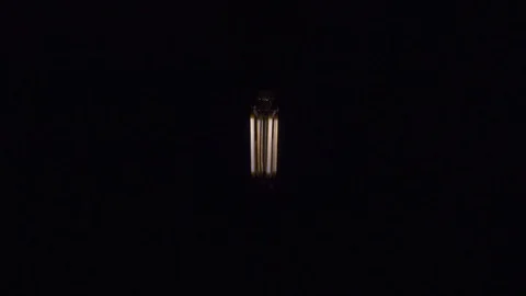 Old style lamp blinking over black background, macro shot. 4k Stock Footage 105469584