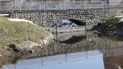 Old style stone bridge through a calm small river during the day Stock Footage 150863973