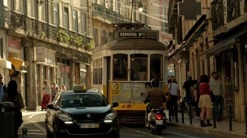 Old style trams passing each other on the Rua do Loreto street in central Lisbon Stock Footage 120008900