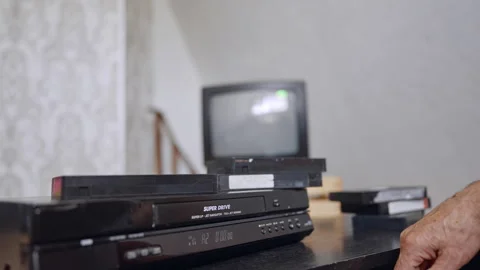Old-style VHS player on the desk. Male hand presses the button on the device. Stock Footage 319890532