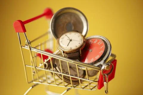Old-styled alarm clock in small shopping cart. Stock Photos