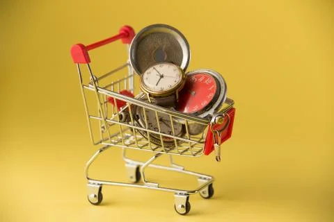 Old-styled alarm clock in small shopping cart. Stock Photos