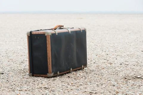 Old suitcase on the beach Stock Photos