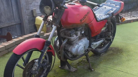 Old Suzuki Motorcycle Parked on Artificial Grass in Backyard Stock Footage 338988436