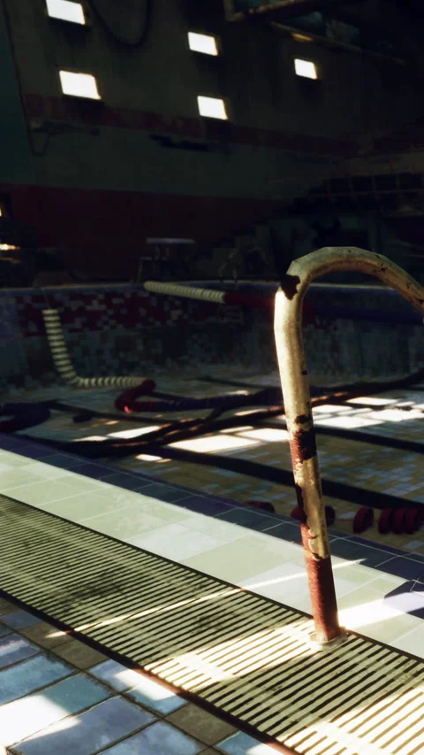 Old swimming pool area with rusted ladder and empty water space Stock Footage 341975574