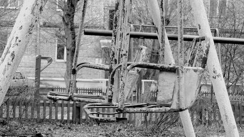 Old Swing with cracked paint slowly sways in the wind Stock Footage 80572073