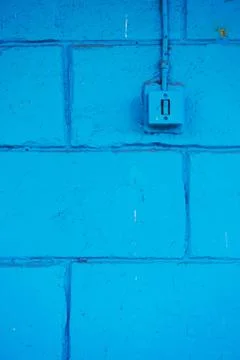 The old switch in the web on the blue brick wall Foto stock