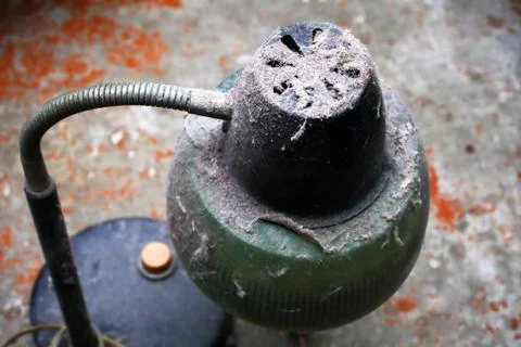Old table lamp under a large layer of dust stands on a concrete floor, select Foto stock