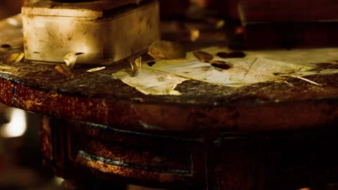 Old table with scattered papers and objects in a dimly lit room Stock Footage 345006972