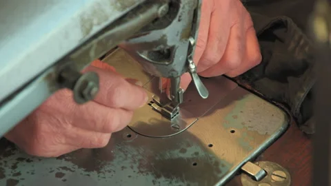 Old tailor tries to put a thread through a needle Stock Footage 147547734