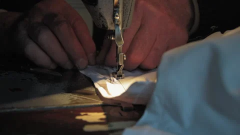 Old tailor works on his old sewing machine Stock Footage 147553507