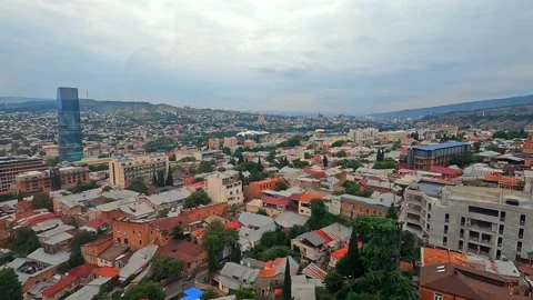 Old Tbilisi rooftops spread across the historic district beside new construction 库存影片 340385087