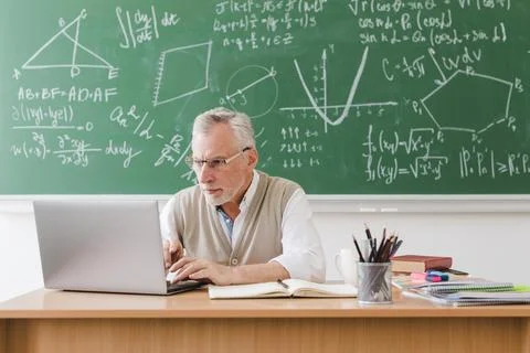 Old teacher using laptop classroom Stock Photos