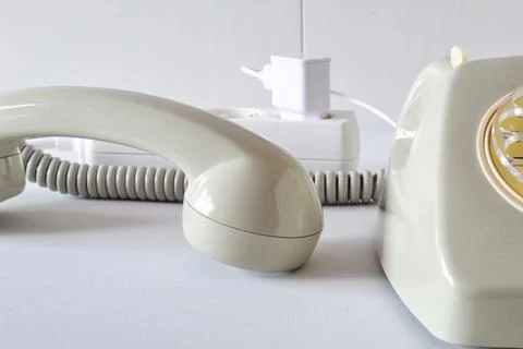 Old technology telephone connected to the electrical network through a plug Stock Photos
