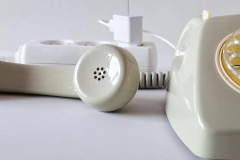 Old technology telephone connected to the electrical network through a plug Stock Photos