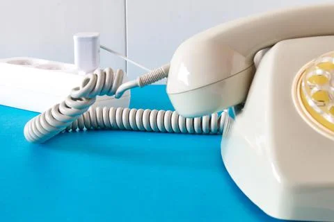 Old technology telephone connected to the electrical network through a plug Stock Photos