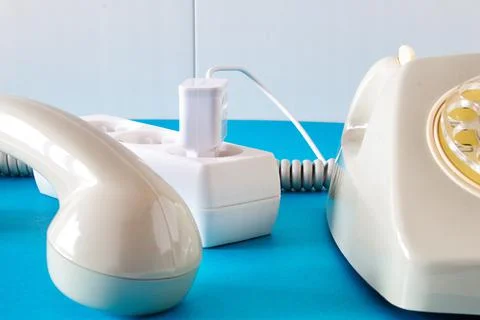 Old technology telephone connected to the electrical network through a plug Stock Photos