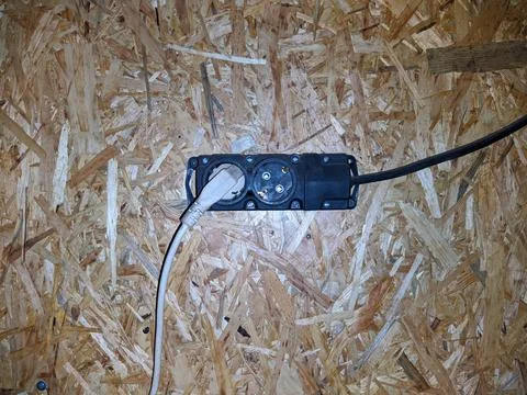 Old tee for a socket in the garage fixed to a wooden wall. Stock Photos
