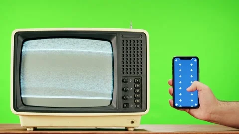 Old television with grey interference screen on green background and smartphone Stock Footage 169114919