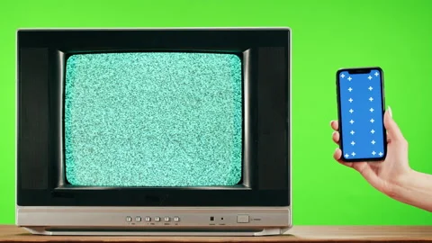 Old television with grey interference screen on green background and smartphone Stock Footage 169115921