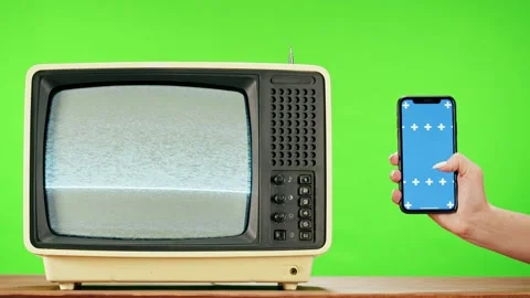Old television with grey interference screen on green background and smartphone Stock Footage 169195442