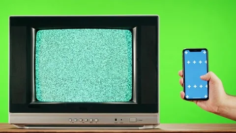 Old television with grey interference screen on green background and smartphone Stock Footage 169196635