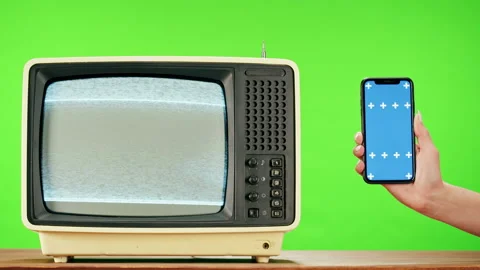 Old television with grey interference screen on green background and smartphone Stock Footage 169198956