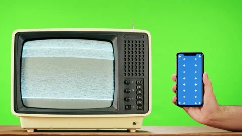 Old television with grey interference screen on green background and smartphone Stock Footage 169309073