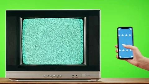 Old television with grey interference screen on green background and smartphone Stock Footage 169309114