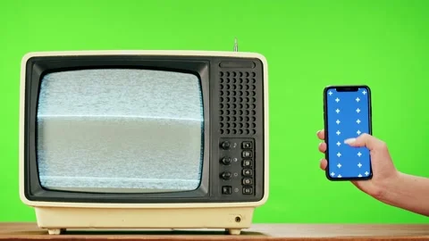 Old television with grey interference screen on green background and smartphone Stock Footage 169309206