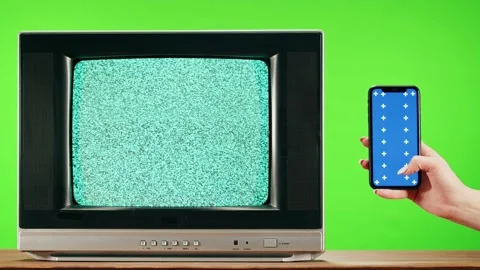 Old television with grey interference screen on green background and smartphone Stock Footage 169309772