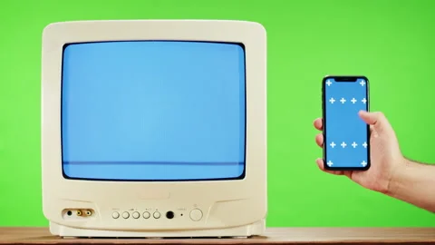 Old television with interference screen on green background and smartphone with Stock Footage 169197155