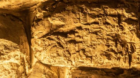 Old textured rocks in wall structure at orange light closeup. Rough boulder.. Foto stock