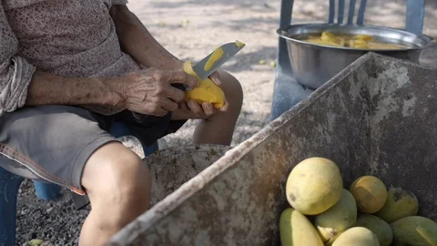 Old Thai Lady Peels Mango Stock Footage 122396941