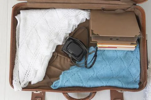 Old things folded in a retro suitcase for travel. Stock Photos