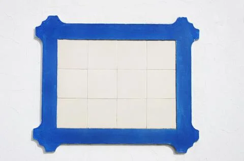 Old tile plaque on white wall Stock Photos