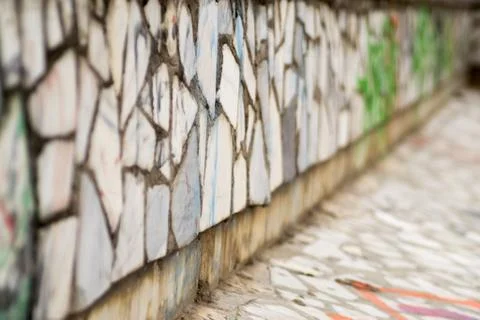 Old tiled brick wall with spray paint vandalism that cannot be read Stock Photos