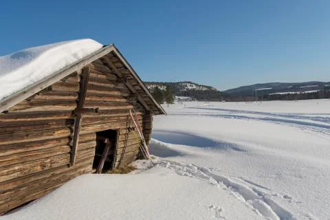 Old timbered barn with a pair of ski leaning against Stock Photos