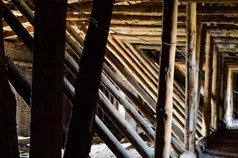 Old timbered dirty loft inside with many wooden logs Stock Photos